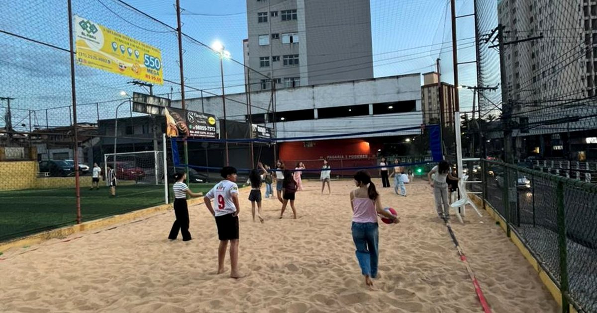 Atividade esportiva em quadra de areia ao entardecer durante programação recreativa