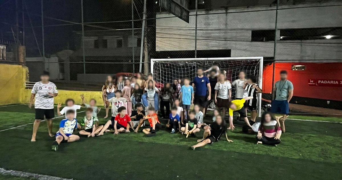 Turma reunida à noite em uma quadra após atividade esportiva da festa